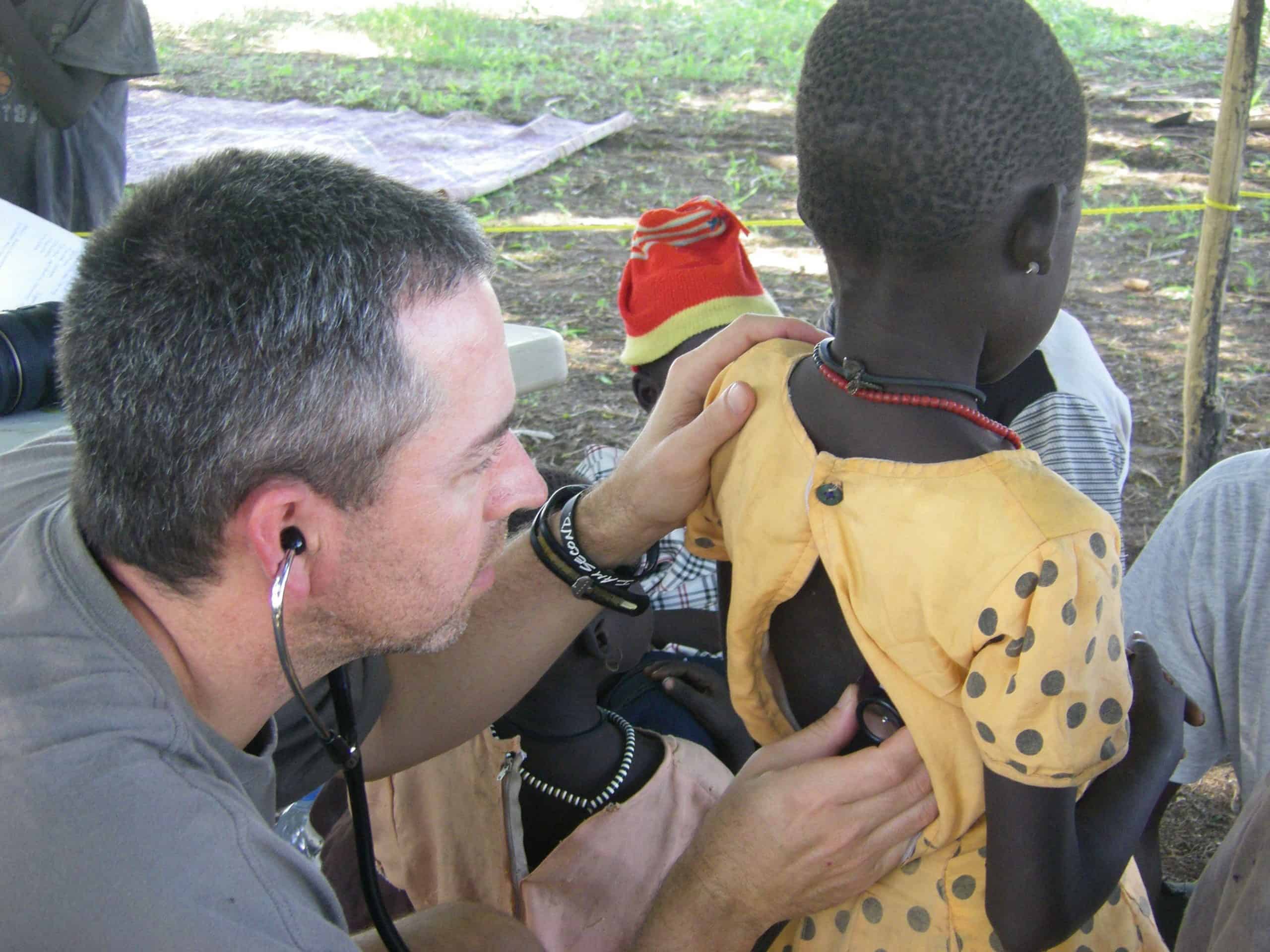 Doctor from Surgical Dermatology Group uses a stethoscope to hear a young boy's breathing