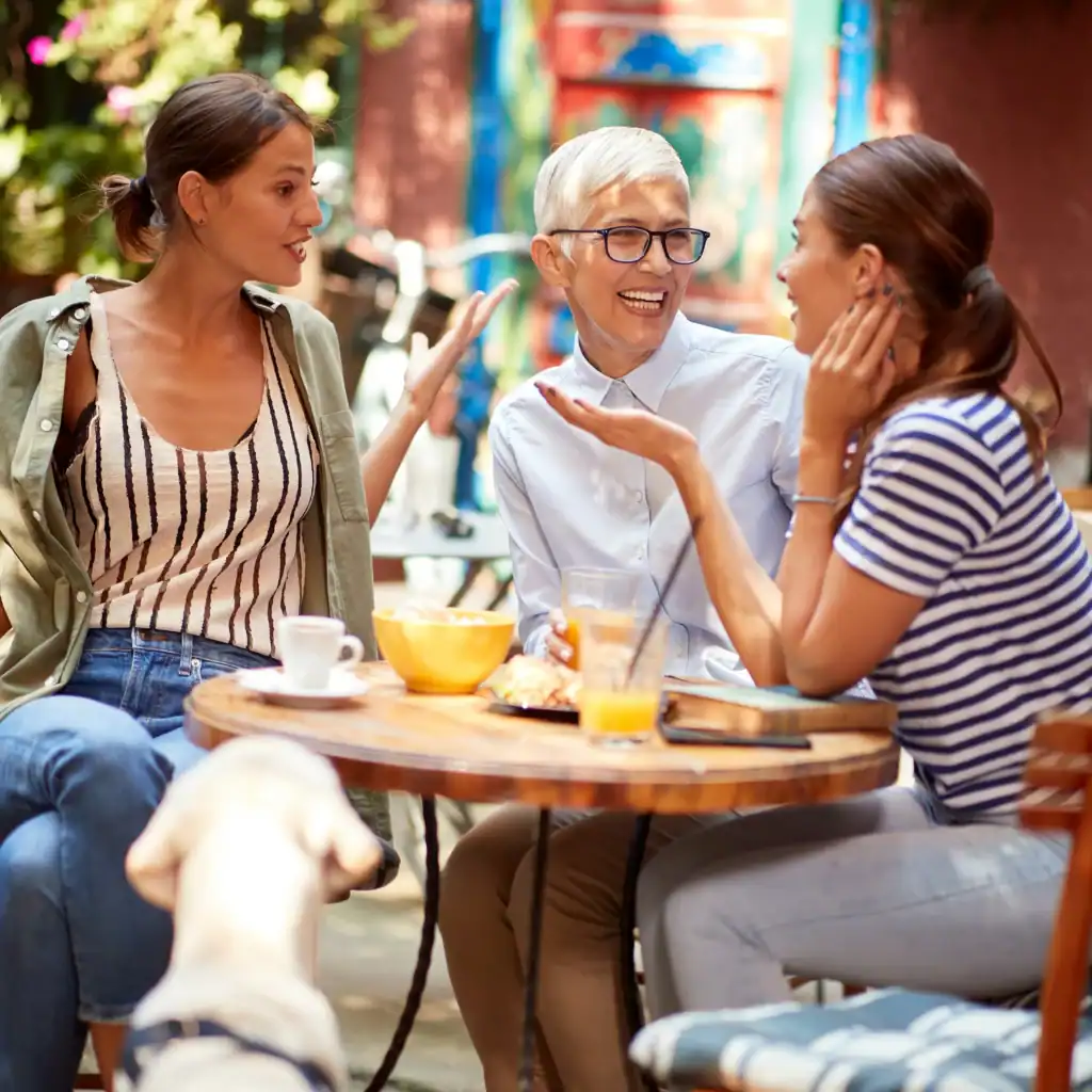Three women of different ages chat at a cafe